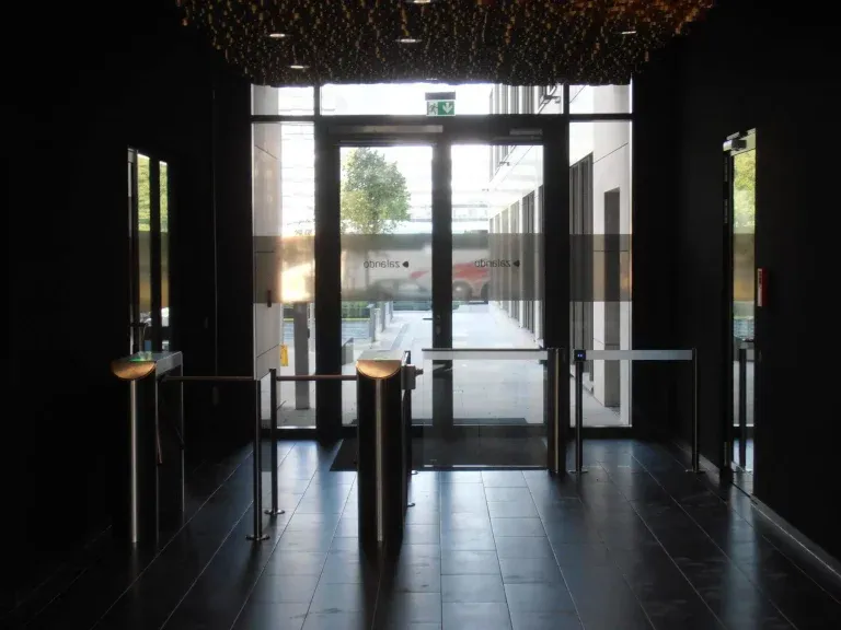 zugang-mit-drehsperre-ganzglas-schiebetuer-und-glasgelaender